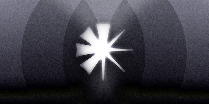 A bright white shape resembling a star or burst of light in the center, set against a dark, background. 